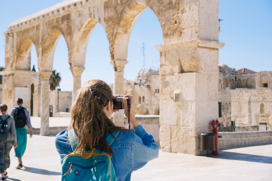 A tourist photographs the ancient stone arches in Jerusalem's Old Town, capturing the essence of travel and history